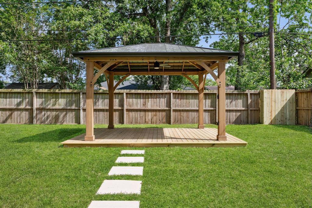 Covered pergola with ceiling fan—perfect for shaded lounging or al fresco dining.