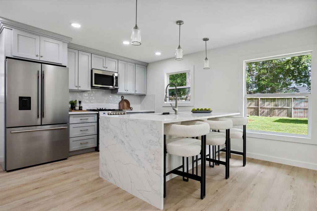 Light gray cabinetry, sleek pendant lighting, and a layout that just works.