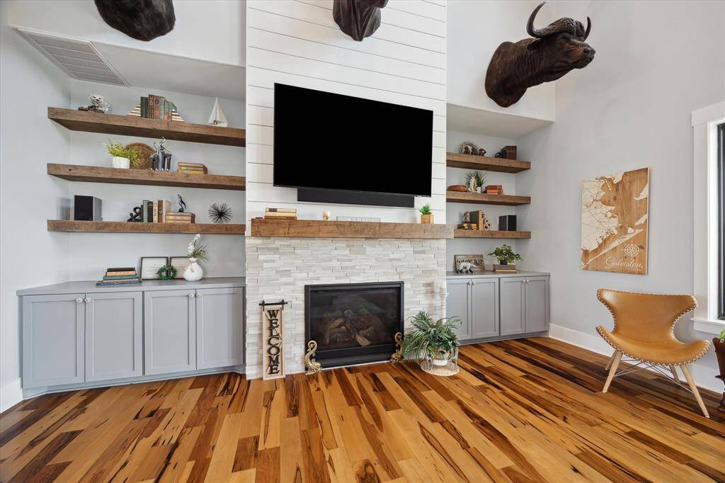Built-in custom cabinets and open shelving define the space, offering both function and style