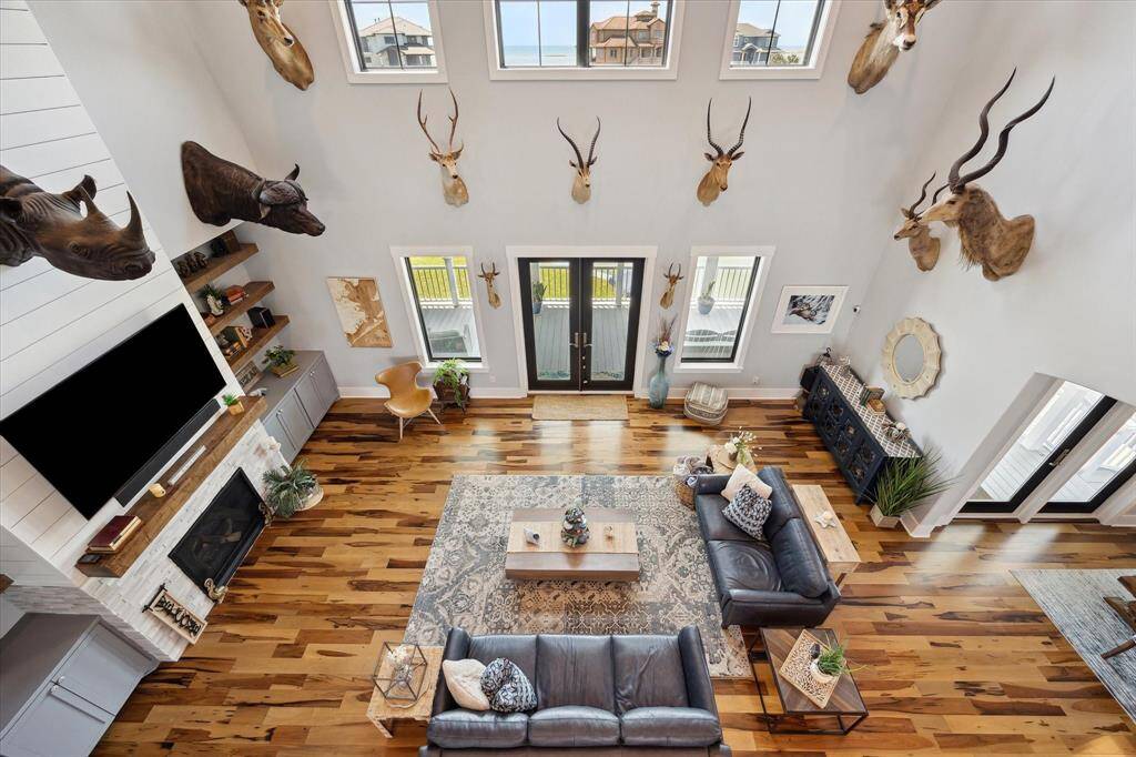 Soaring 20-foot ceilings and a dramatic 2-story gas fireplace with shiplap and stone detailing make this living room a showstopper