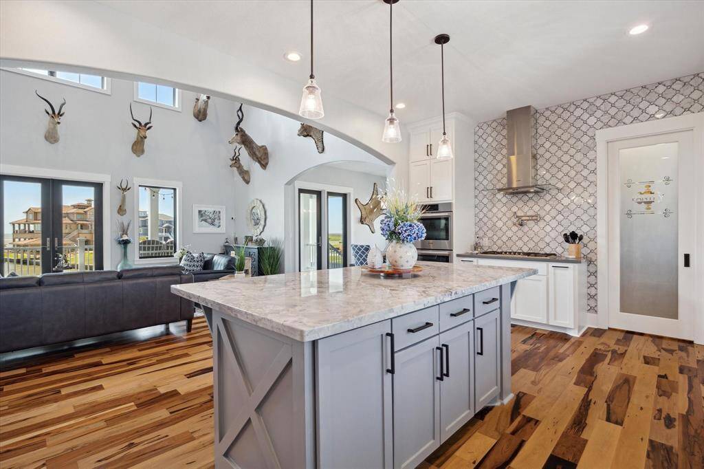 This coastal-inspired kitchen is both stylish and functional, featuring an elegant custom island perfect for gathering and entertaining & a layout that adds both charm and practicality to the heart of the home