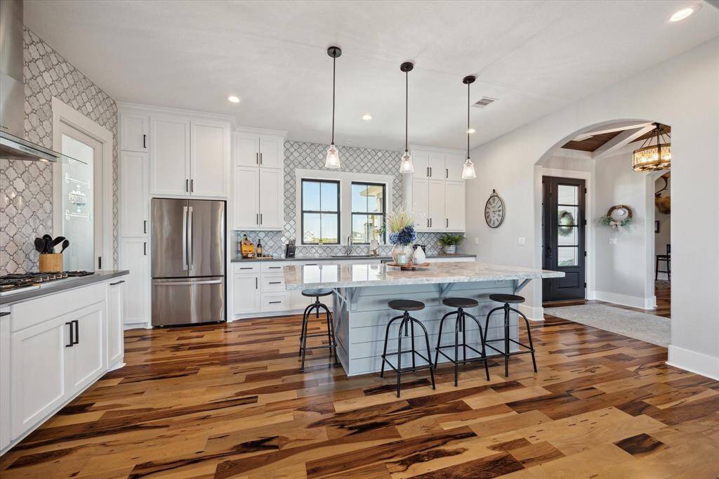 GE refrigerator, Kitchen-Aid under-counter ice maker, breakfast bar and gorgeous Brazilian Pecan engineered flooring complete the ensemble