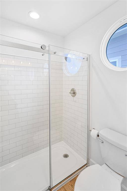Glass-enclosed, sliding door, standing shower elevates the sleek modern look of the bathroom.