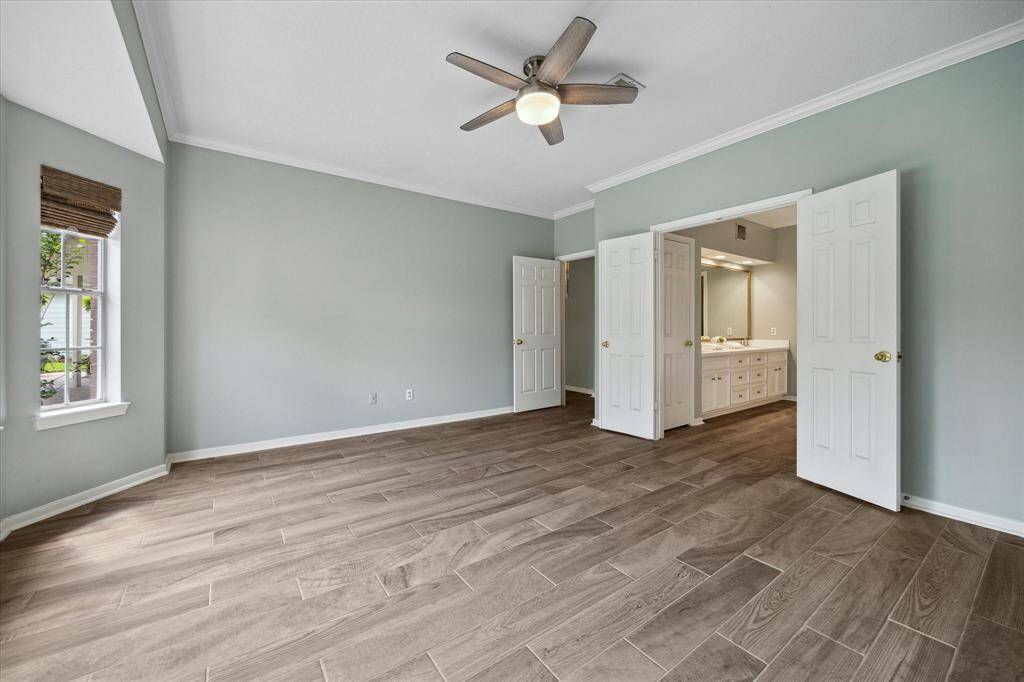 The large primary bedroom is conveniently located on the first floor, just off the main living area—offering privacy, comfort, and easy access, all while enjoying peaceful views of the backyard retreat