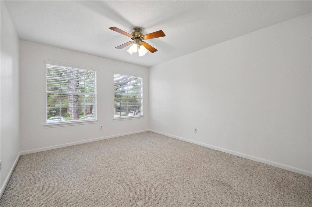 Bedroom four is tucked just off the upstairs game room and features two large windows that fill the space with natural light and offer a charming view of the front of the home—making it a bright and inviting retreat.