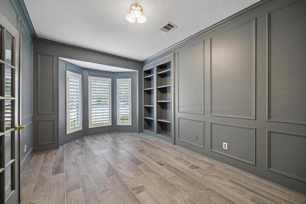 The study is a showstopper with its painted paneled walls, wood-look tile flooring, classic shutters, and custom built-ins—who wouldn’t want to work in a space this stylish and inspiring?