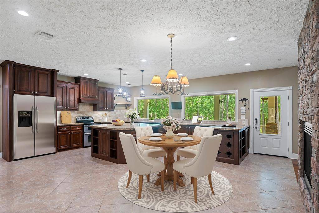 Morning coffee indoors?  Why yes, we think we will!  A charming chandelier anchors the space for a breakfast table, giving you a place to connect morning, noon or night!  A door offers direct access to the outdoor spaces, but let's continue to take a look around the home!