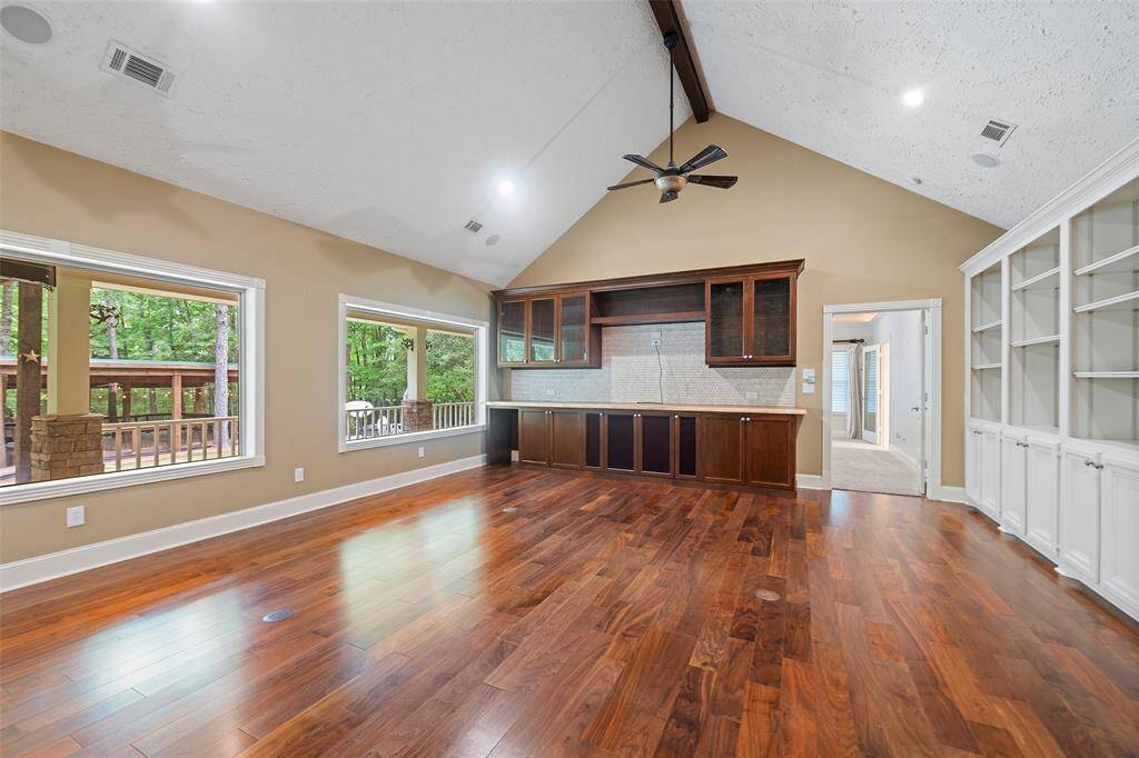 Back into the family room, you see how the natural light from the windows flow into the space offering gorgeous views of your own piece of the forest. Custom cabinets provide so much additional storage, and areas to display your most treasured keepsakes for all to see!