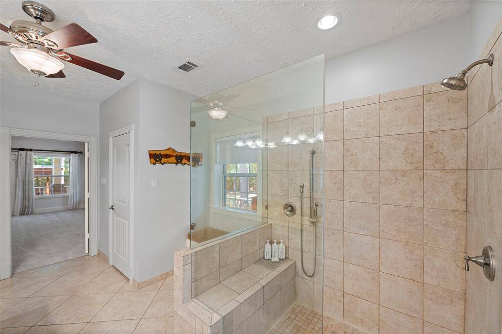 An enlarged glass enclosed shower with bench seat and detachable shower head helps you wash away the cares of the day!