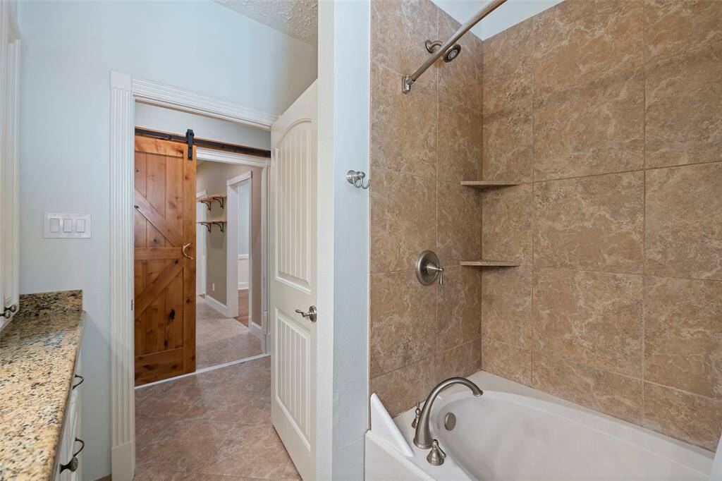 It also features shower/tub combination with tile surround is so easy to maintain! Step out into the hallway and you have quick access to the kitchen for those late-night snack attacks just past the barn door!