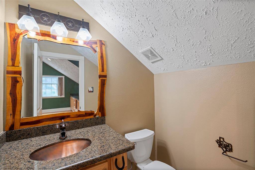 A half-bath features a copper sink and vanity for storage!  The touches of Texas can be seen throughout!