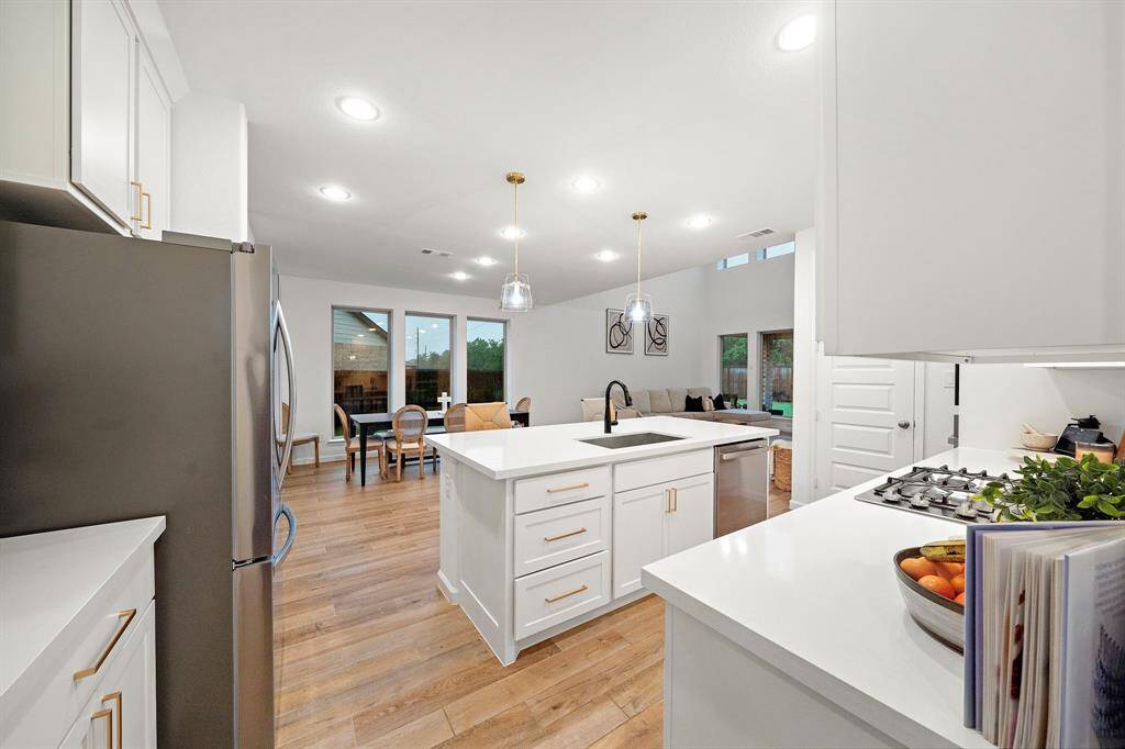 The kitchen features white cabinets,creating a clean and timelessaesthetic.