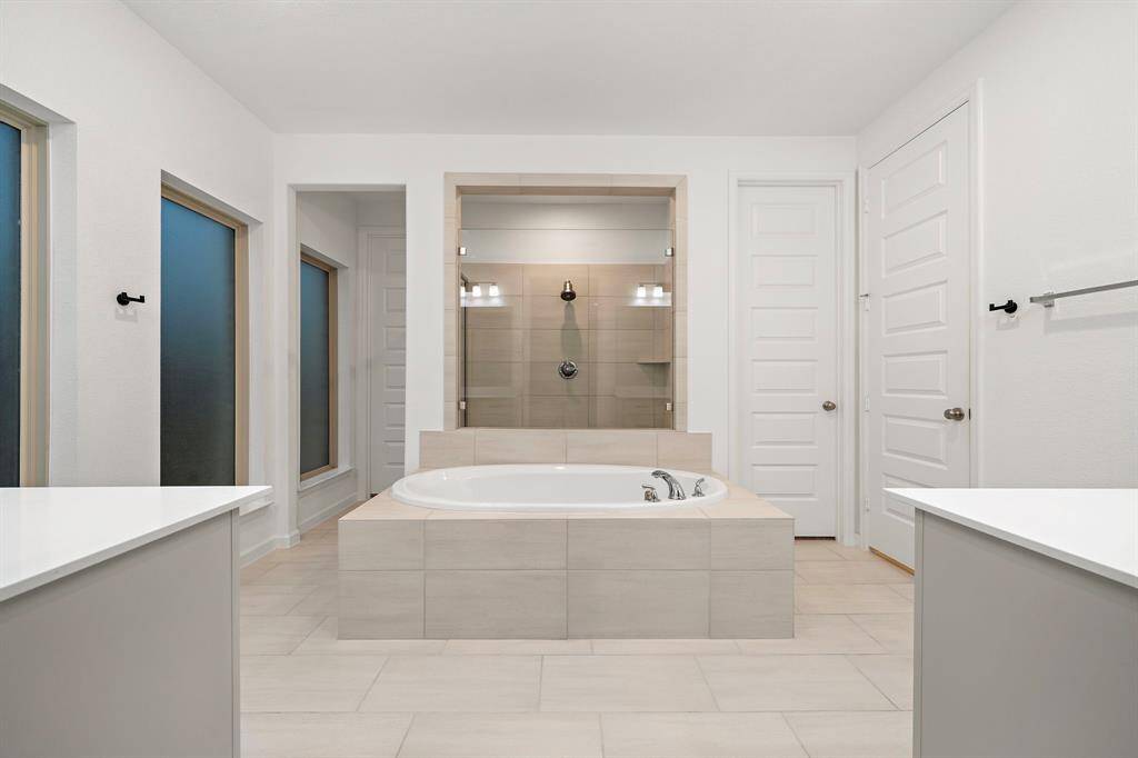 The primary bathroom features tile floors, huge walk-in shower, and soaking tub.