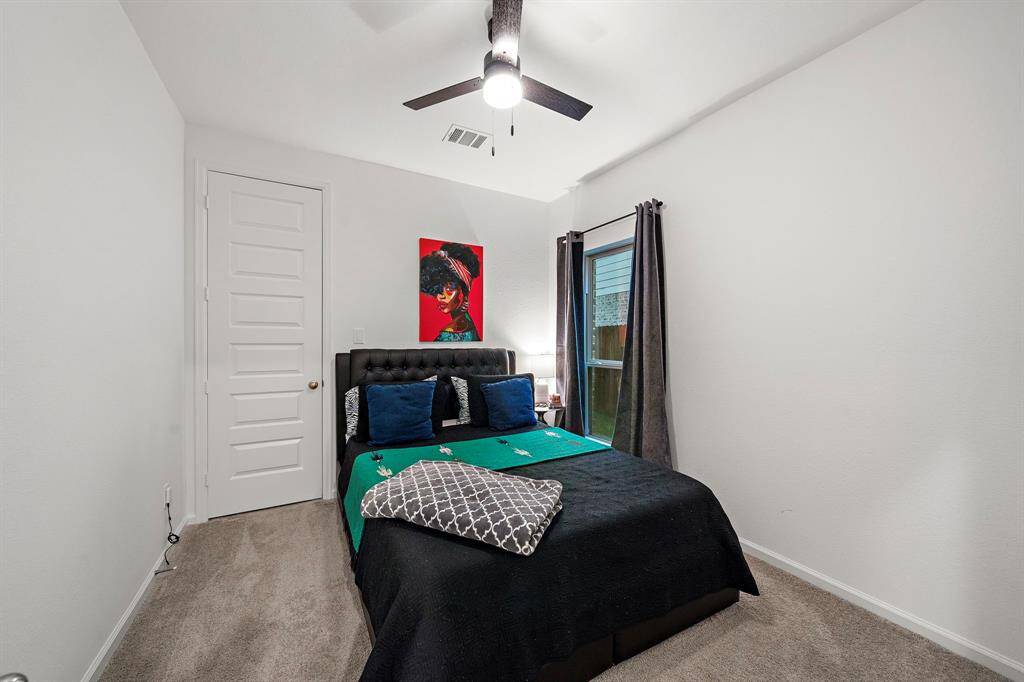 Secondary bedroom features awindow and plush carpet.
