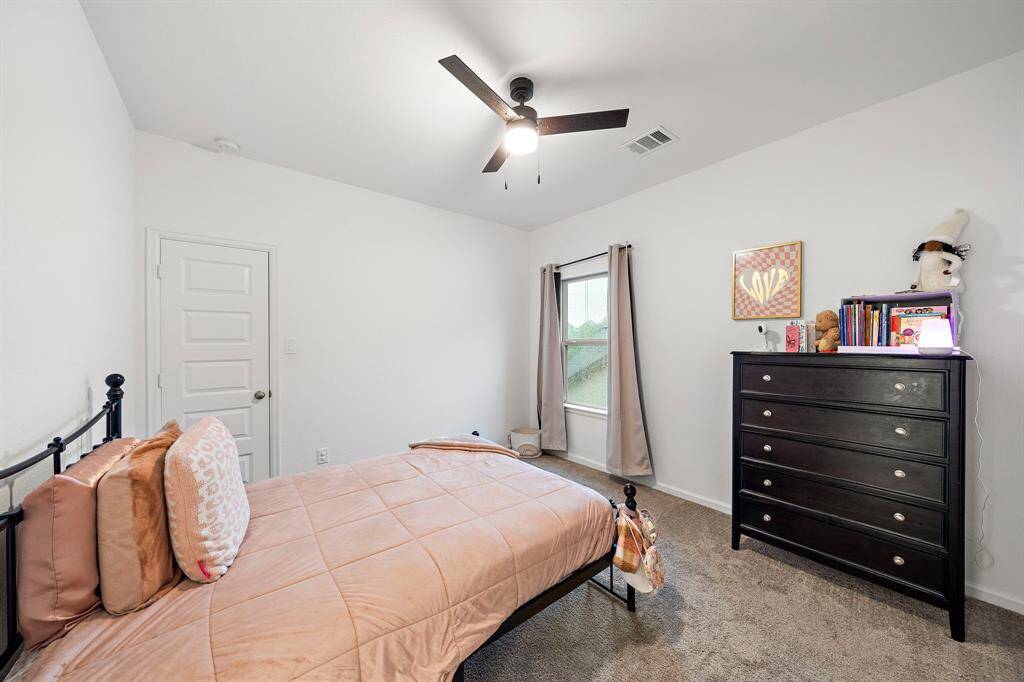 Third bedroom features awindow and plush carpet.