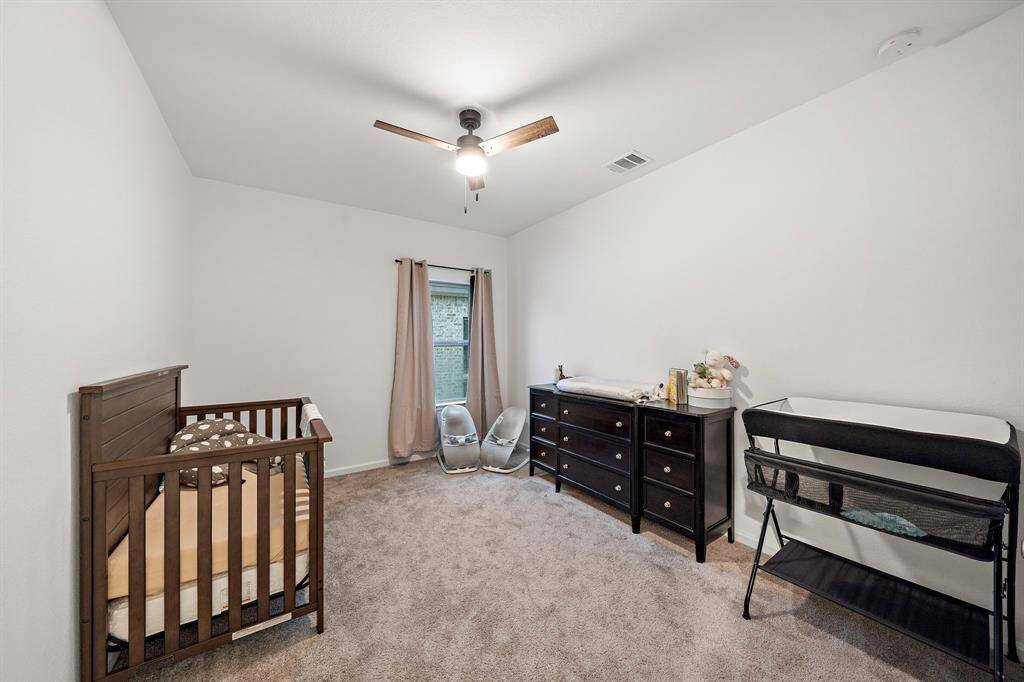 Fourth bedroom features awindow and plush carpet.