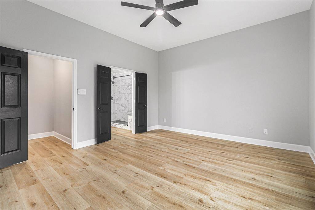 The primary bedroom features black doors leading to a closet and an en-suite bathroom.