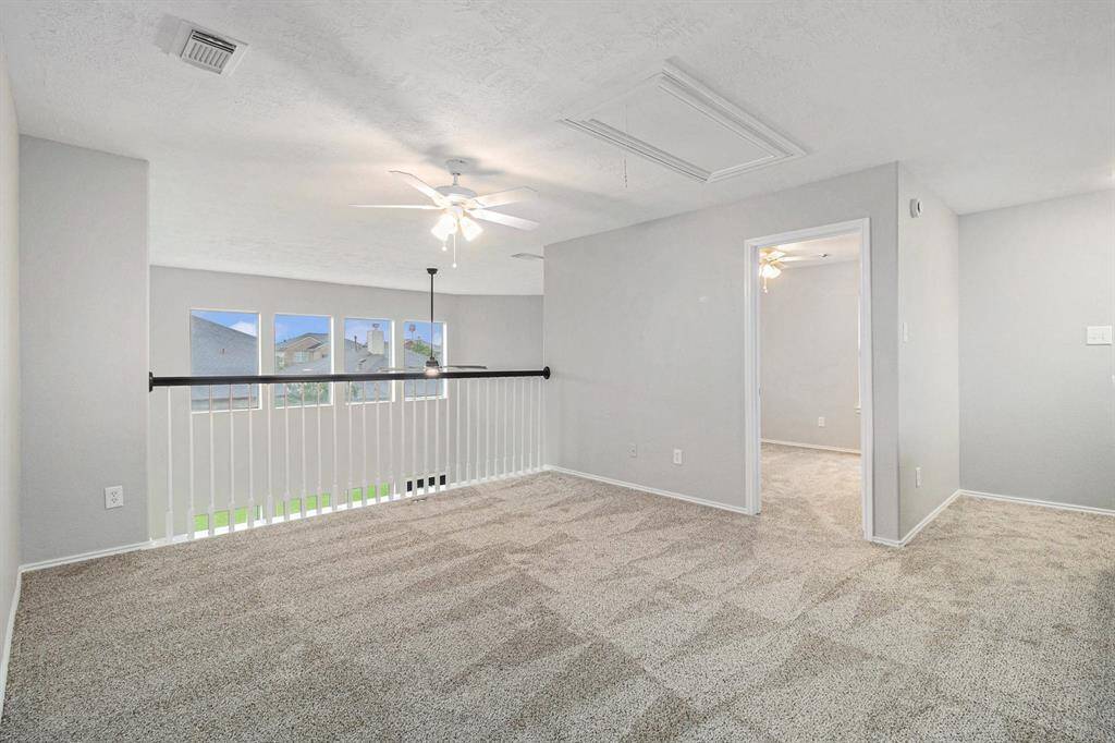This photo showcases a bright, open loft area. There's an adjacent secondary bedroom visible through a doorway.
