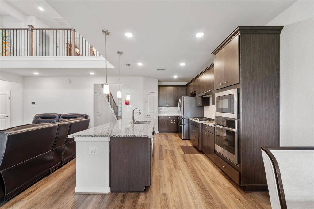 The spacious kitchen offers ample counter space, modern appliances, and a large center island perfect for prep work, casual dining, or entertaining.