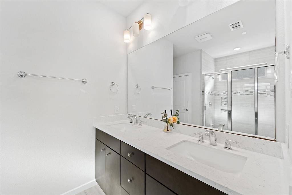 A large mirror and contemporary lighting enhance the spacious dual-sink vanity, perfect for getting ready with ease.