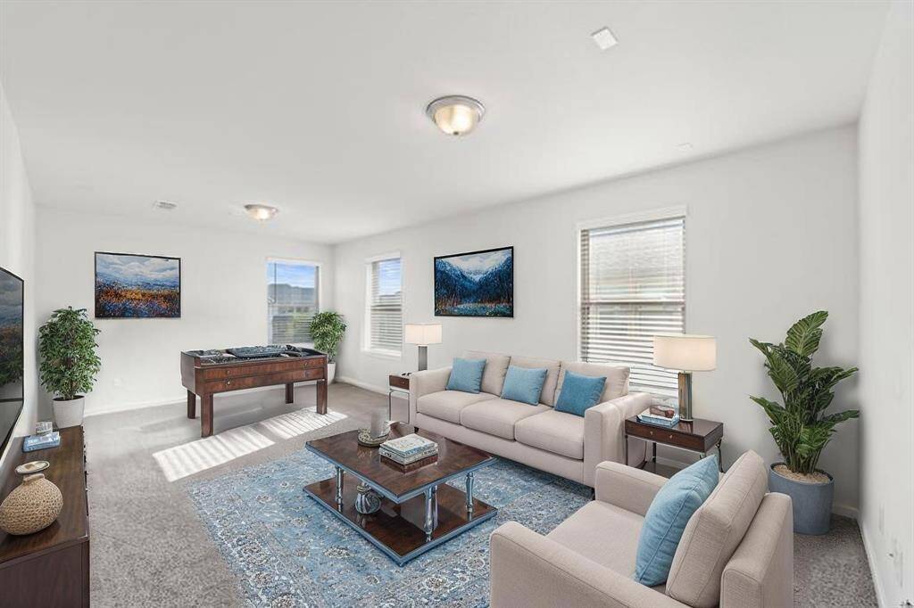 Generously sized game room offers multiple windows for natural light, plush carpeting, and flexible space for entertainment or relaxation. Enjoy ample square footage and potential for a media setup, playroom, or second living area. (Virtually Staged)