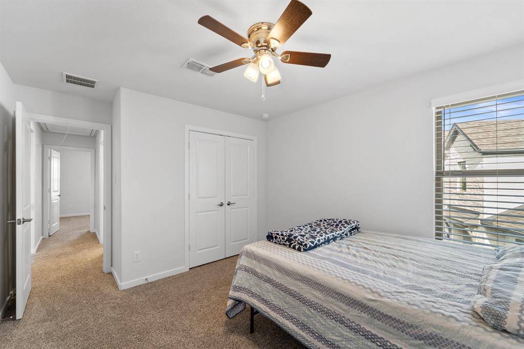 Alternate angle of the same bedroom showcasing a double-door closet and access to the upstairs hallway.