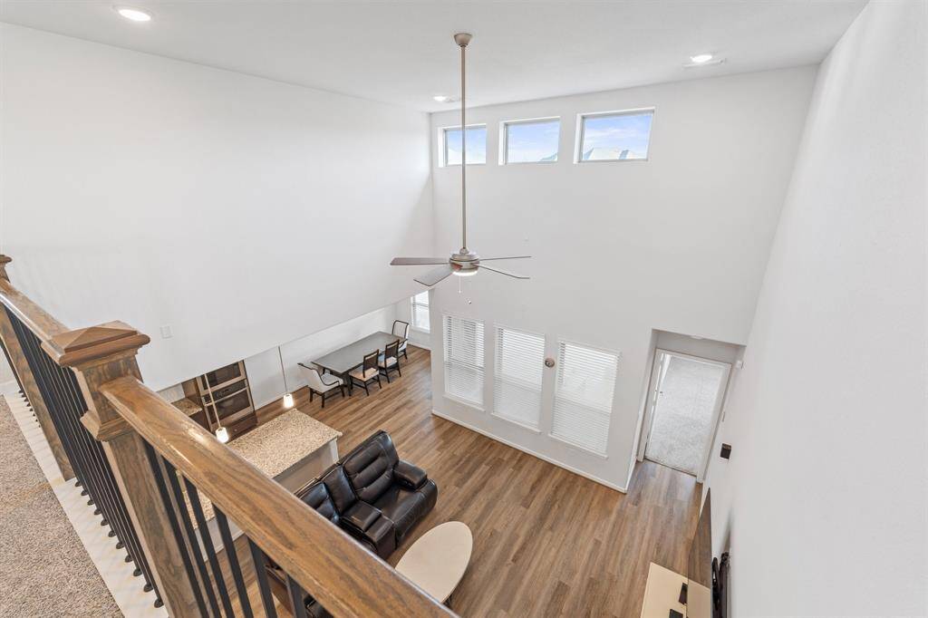 Bird’s-eye view from the landing highlights the soaring ceilings in the living area below, plus a view of the open-concept kitchen and dining.