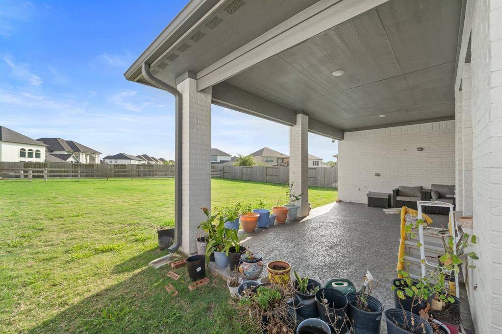 Enjoy seamless indoor-outdoor living with this extended covered patio overlooking a generous, fully fenced backyard.