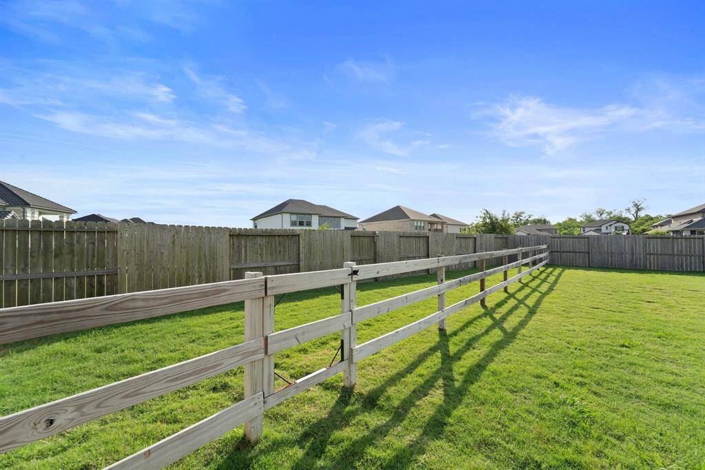A partial privacy and ranch-style fence combo adds charm and flexibility to this sprawling backyard oasis.