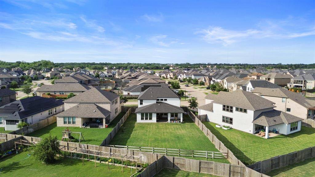 The large backyard is a standout feature, offering privacy and space, visible from this elevated perspective.
