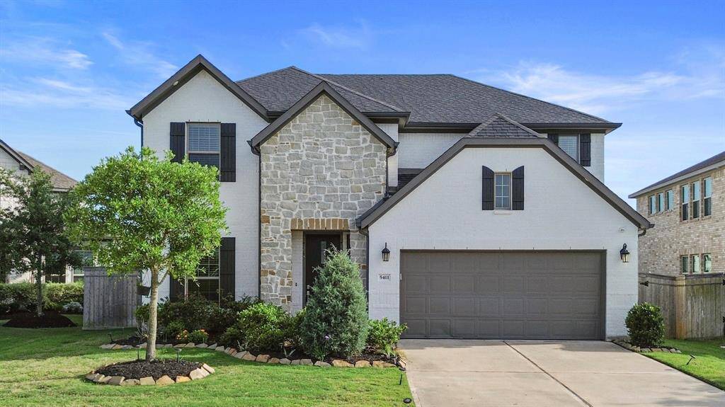 Charming curb appeal with stone accents, dark trim, and manicured landscaping welcome you home.