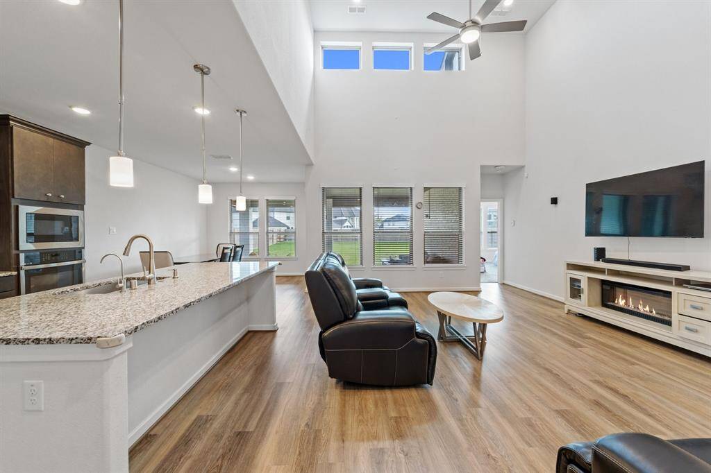 Enjoy seamless flow from the kitchen to the living room in this open-concept space, highlighted by soaring ceilings, large windows, and beautiful finishes.