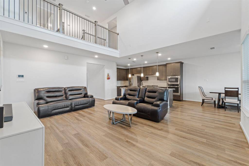 An inviting living space with abundant natural light and a view of the upstairs loft, designed for comfort and connection.