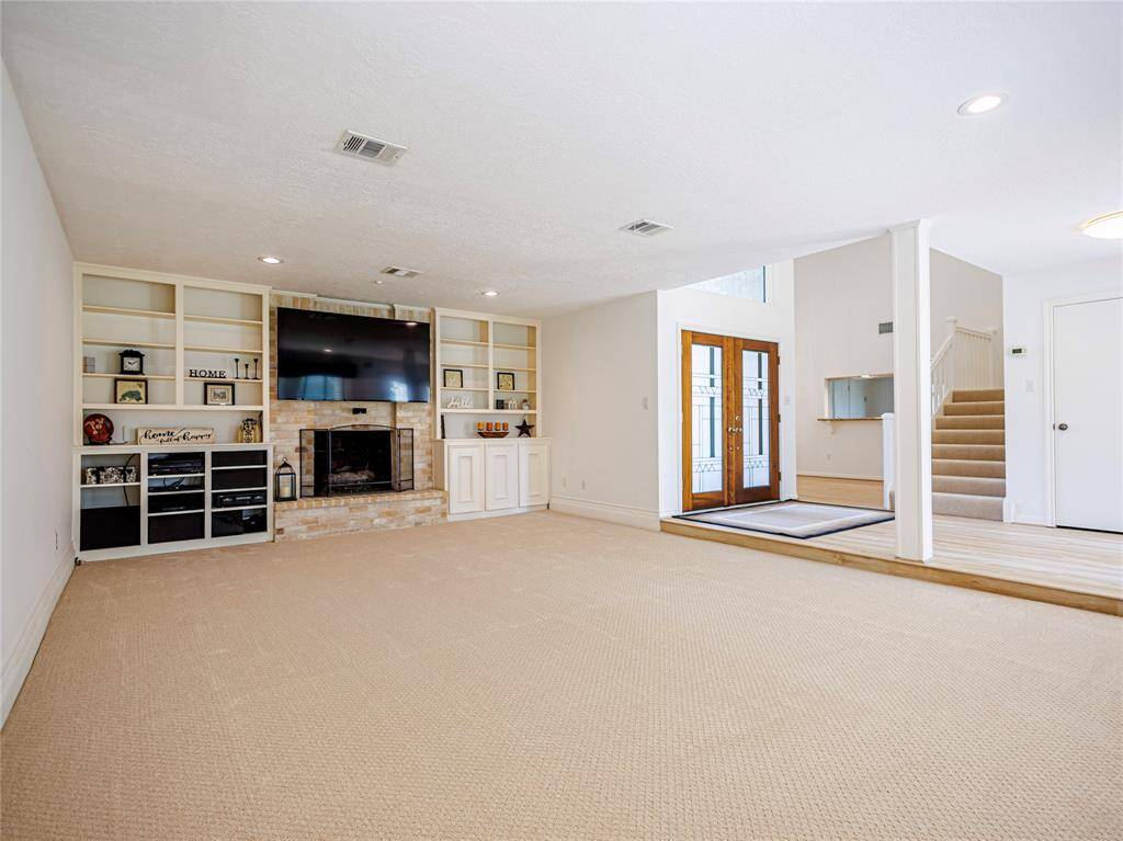 Cozy fireplace, built-ins & new designer carpets in large den. Even the TV & mediat equipment stay with the house.