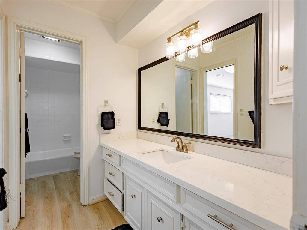 One of two upstairs bathrooms with new quartz countertops & resurfaced bathtub.