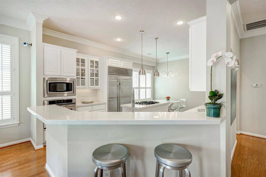Quartz countertops and built-in Sub-Zero fridge with island cooktop