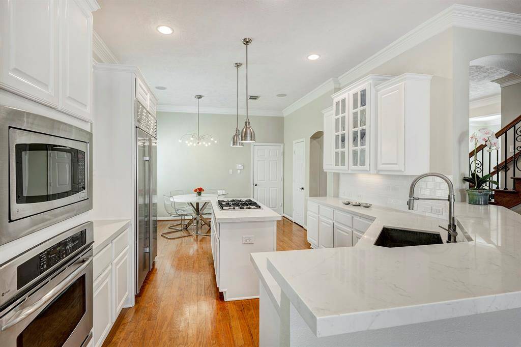 Quartz countertops and built-in Sub-Zero fridge with island cooktop
