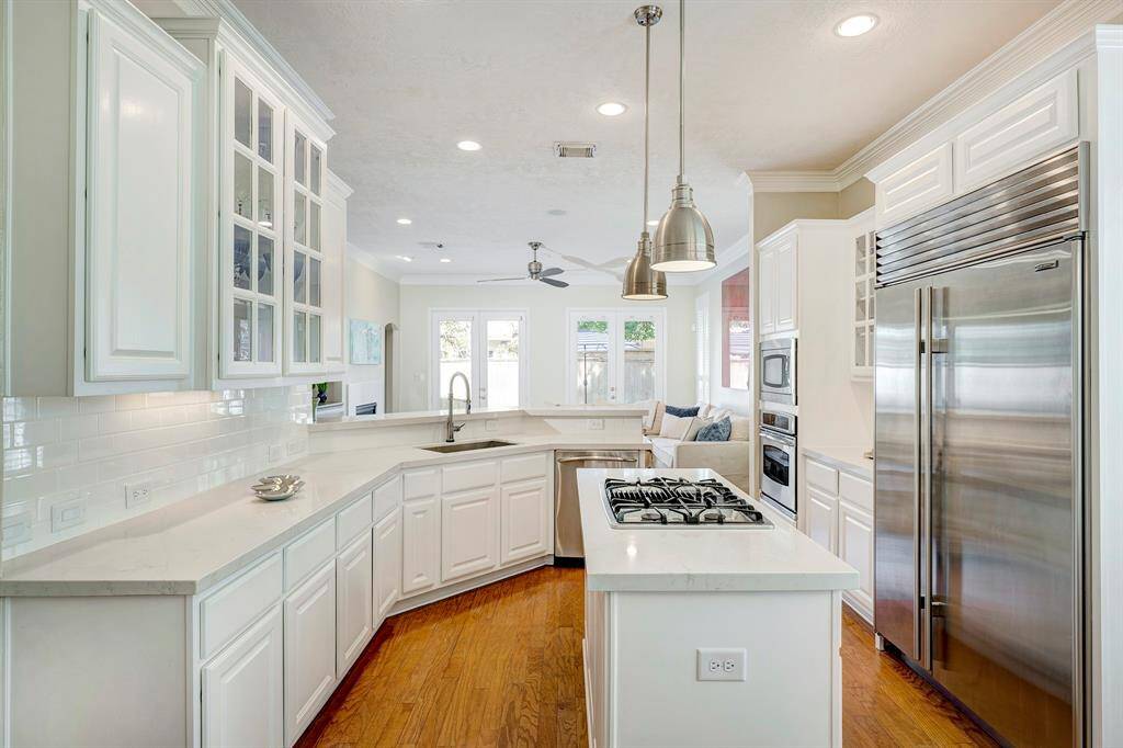 Quartz countertops and built-in Sub-Zero fridge with island cooktop