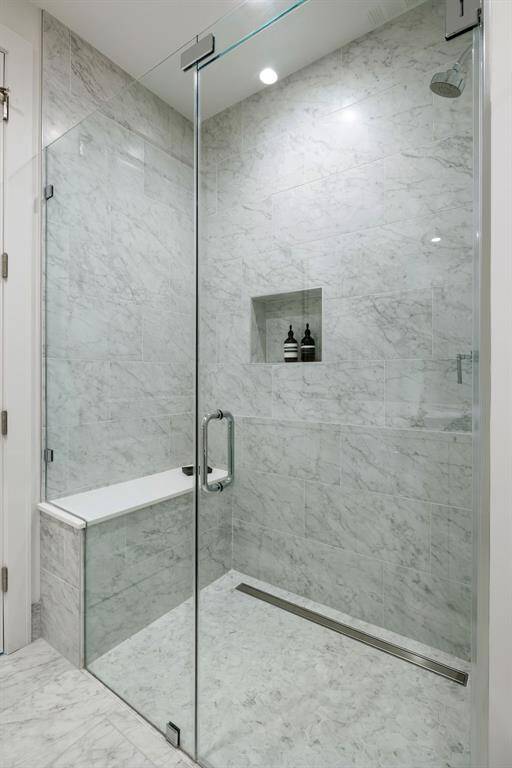 Secondary guest bathroom glass-framed shower with shower seat