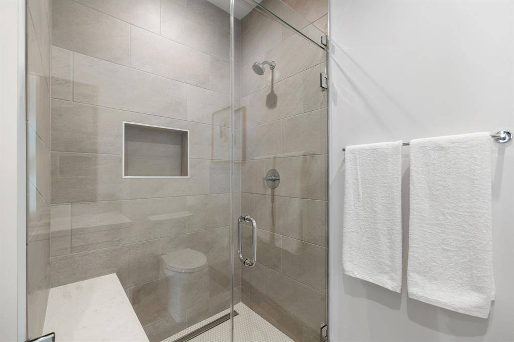 Alternate view of the guest bathroom with glass-framed walk-in shower.