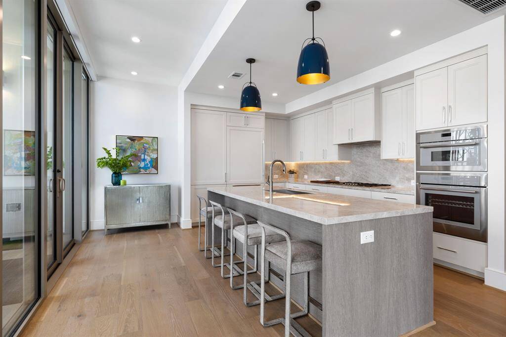 Functional Gourmet chef’s kitchen boasts sleek, modern design, beautiful porcelain counter-top, Thermador appliances, Sub-zero refrigerator with two freezer drawers, wine chiller and glass sliding door leading to a private balcony
