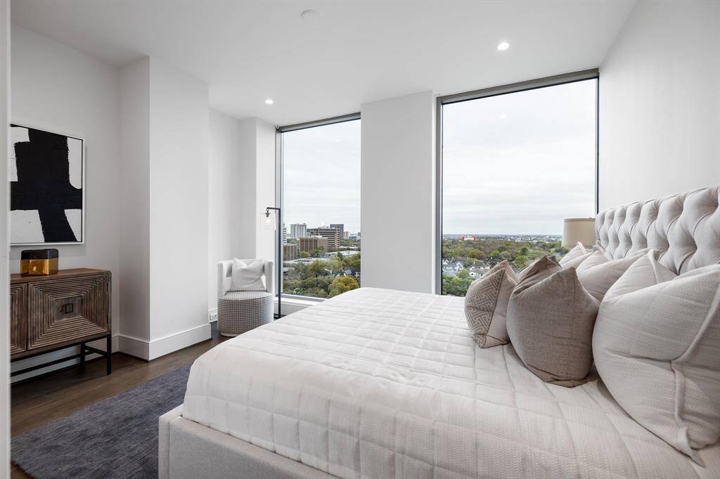 Primary bedroom with floor to ceiling windows.