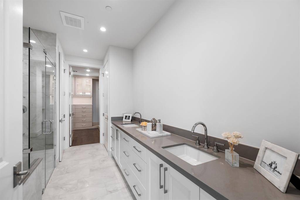 Primary bathroom featuring dual sinks, walk in shower and tub.