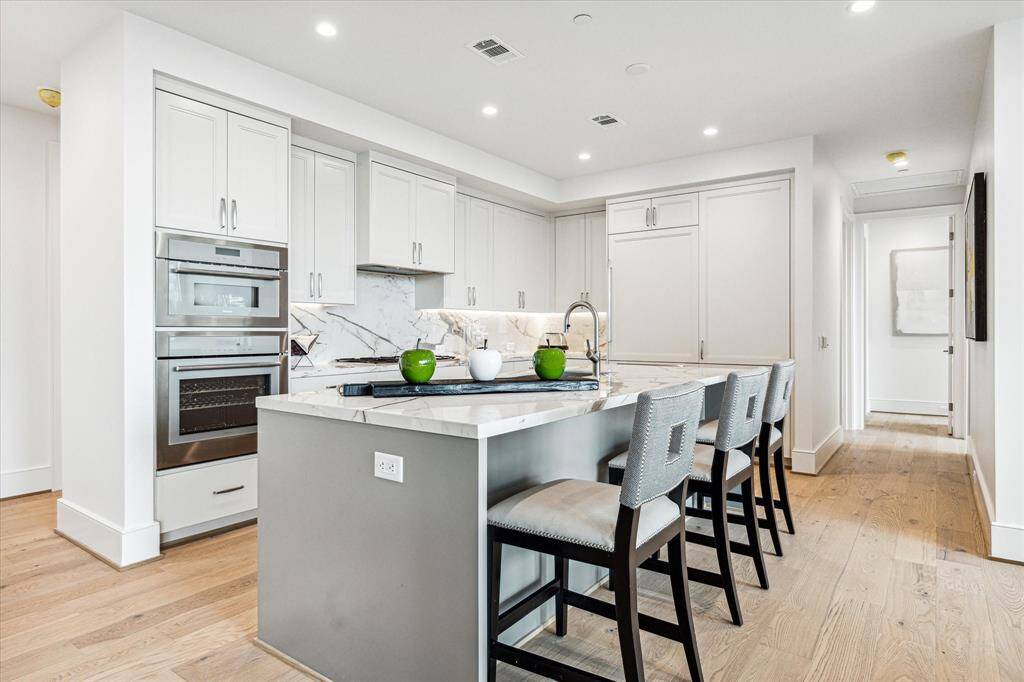 Alternate view of the kitchen with abundant storage space, Thermador appliances, wine chiller and Sub-zero refrigerator with two freezer drawers.