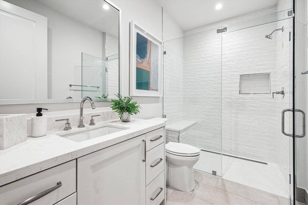 Secondary En-suite guest bathroom with glass framed walk-in shower.
