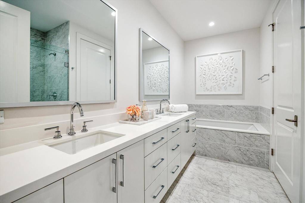 Primary bathroom with dual sinks, soaking tub, glass-framed walk-in shower with seat, private water closet, linen closet and a large walk-in dressing area