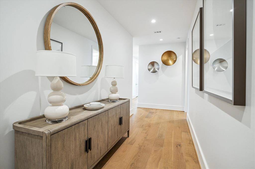 Featuring wide-plank hardwood floors and soaring ceilings, the entryway sets the tone for the home’s Modern style.