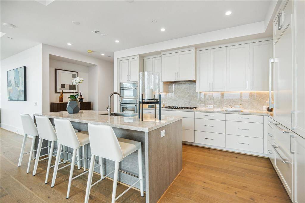Center island features a built-in sink, and breakfast bar seating.