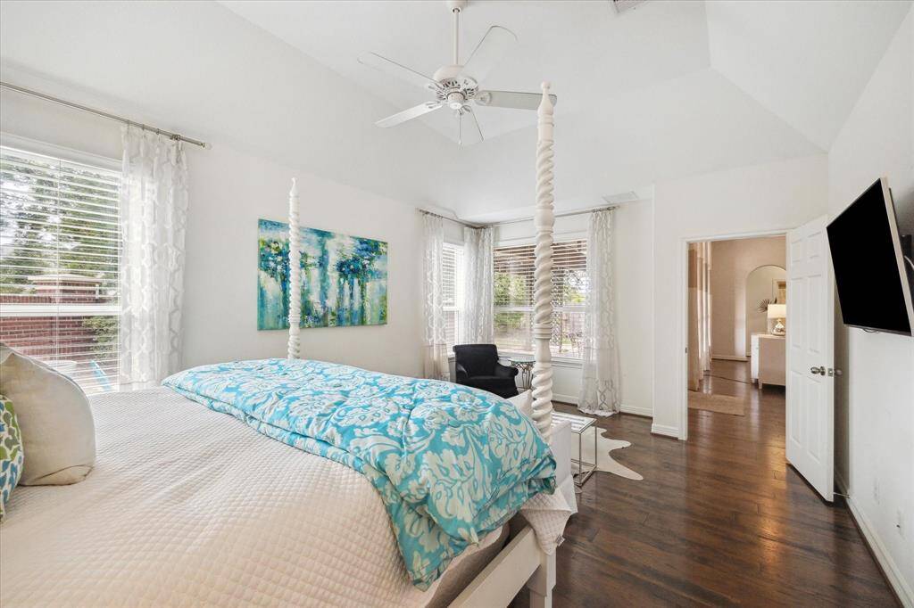 The private primary suite is located in the rear left corner of the home, away from the other bedrooms. It boasts a walk-in closet and a charming sitting area framed by corner windows with peaceful views of the backyard.