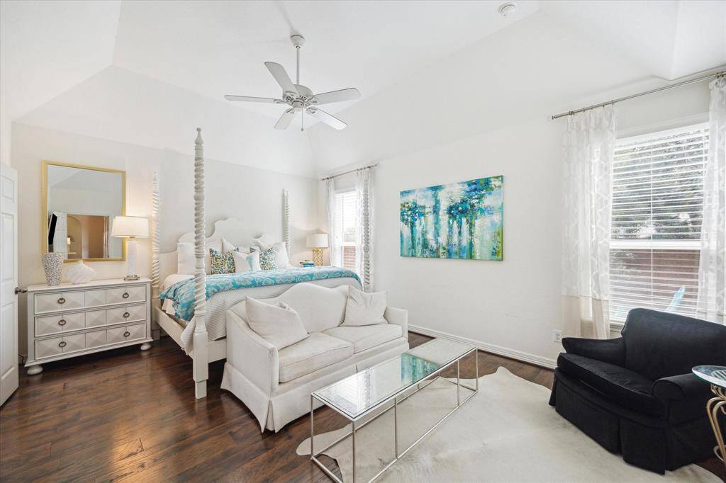 The private primary suite is located in the rear left corner of the home, away from the other bedrooms. It boasts a walk-in closet and a charming sitting area framed by corner windows with peaceful views of the backyard.